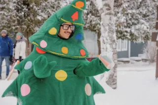 Personne déguisée en sapin de Noël dans la neige