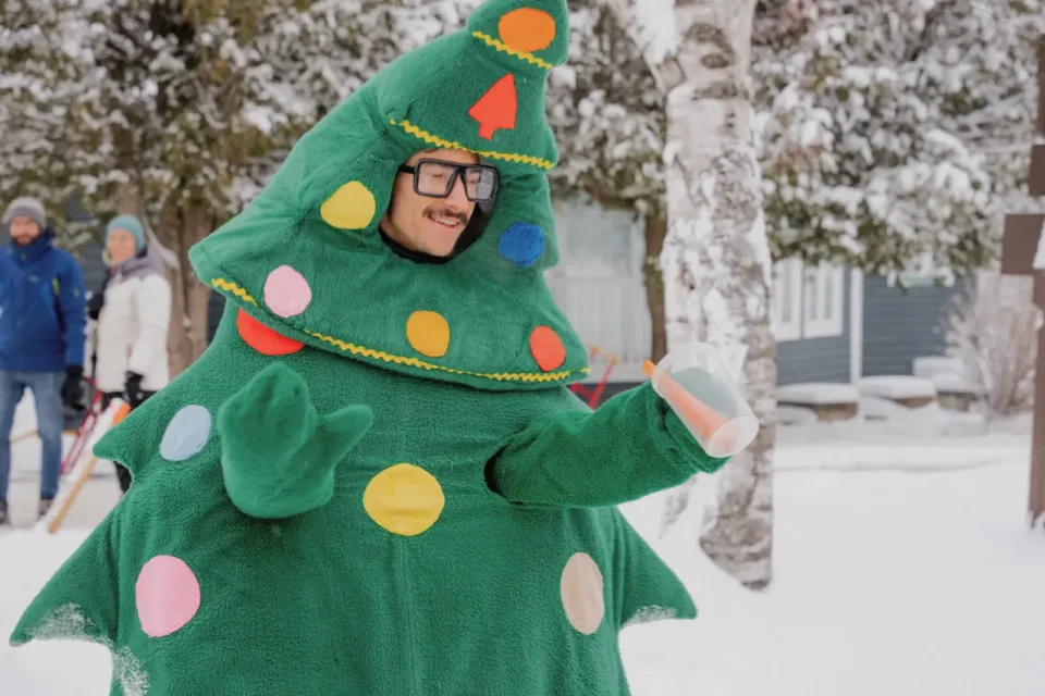 Personne déguisée en sapin de Noël dans la neige