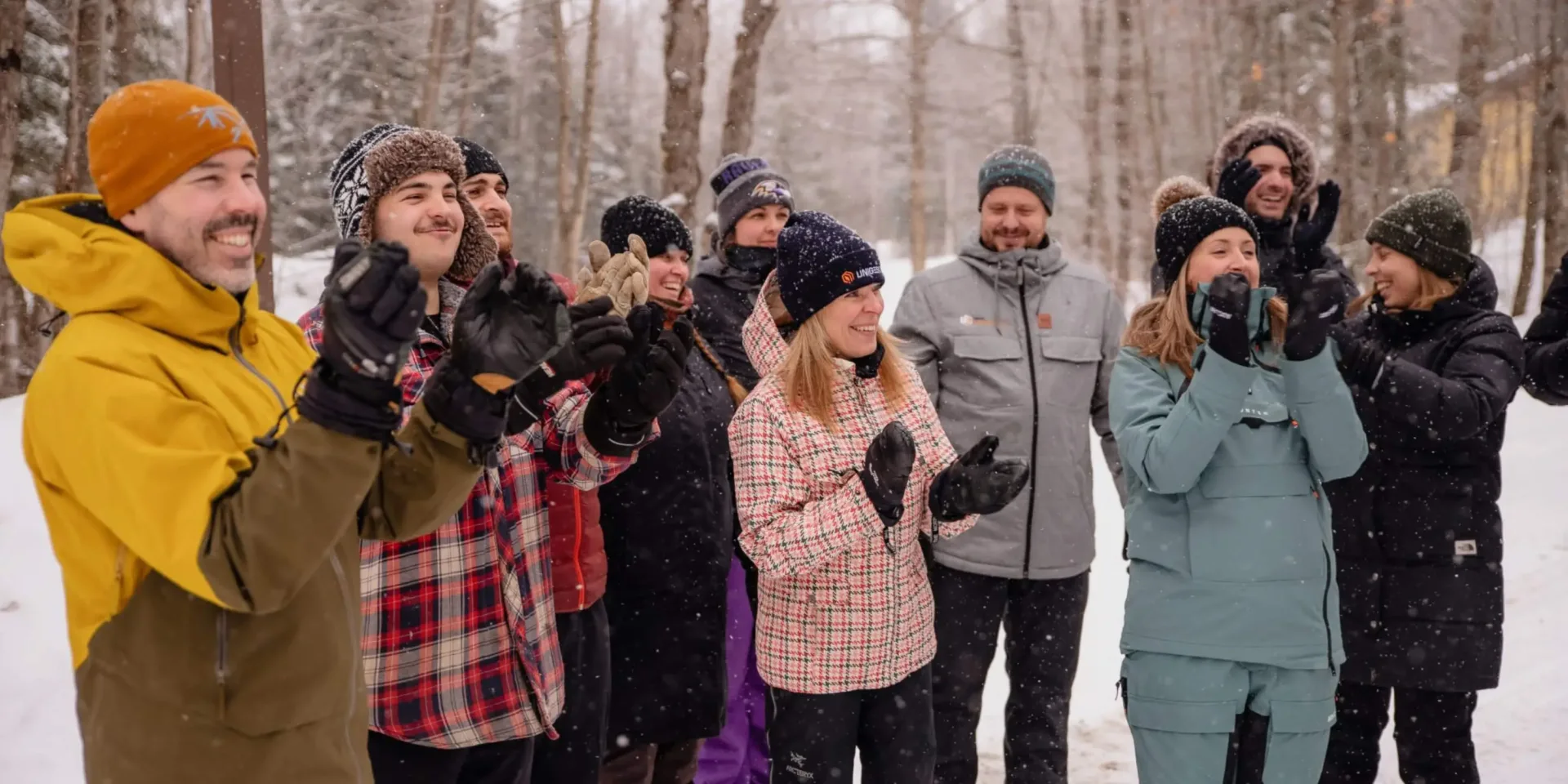 Group of colleagues clapping in snowy forest
