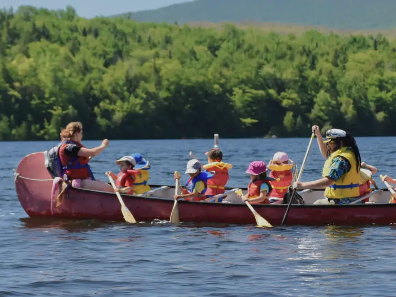 Enfants et adultes en canoë sur un lac