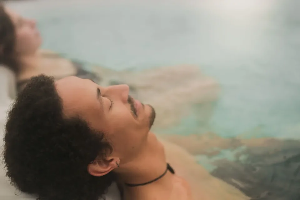 Homme se relaxant dans un bain thermal, femme derrière