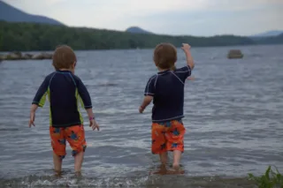 Deux enfants jouant dans un lac en montagne