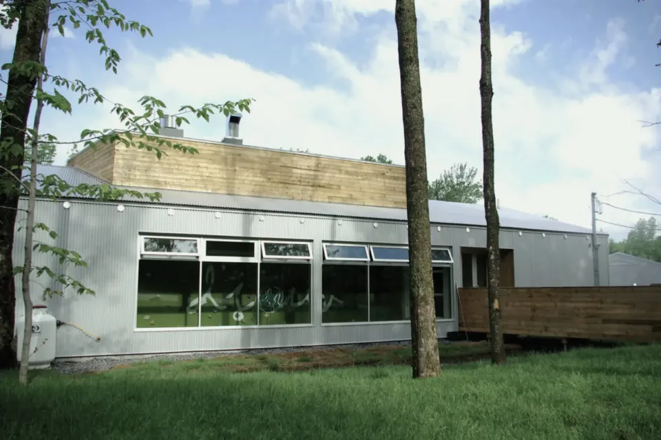 Modern metal and wood building surrounded by trees