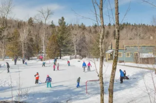 Enfants jouant au hockey sur patinoire enneigée