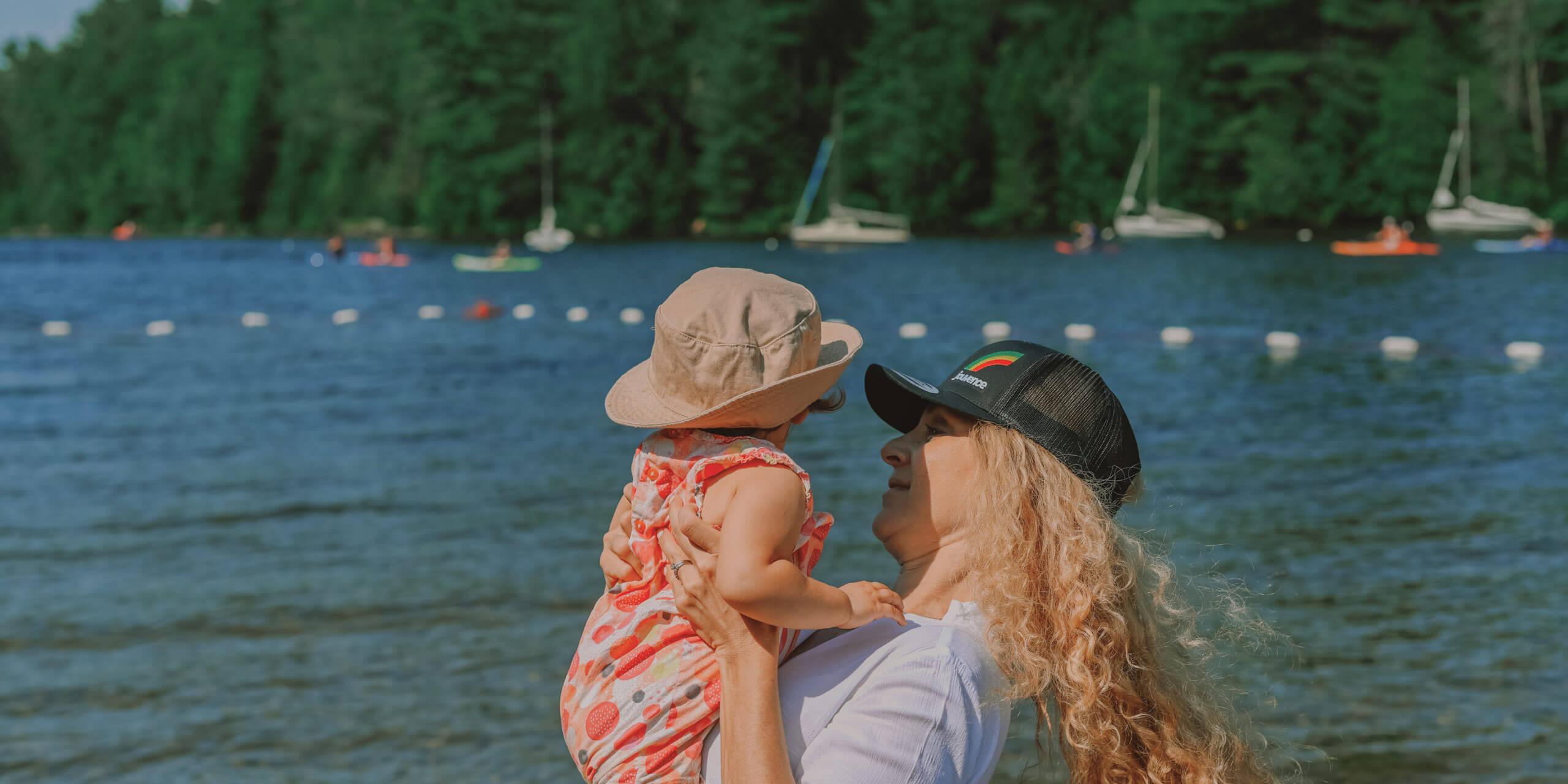 Femme tenant bébé au bord d’un lac