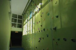 Indoor rock climbing wall with colorful holds and ropes