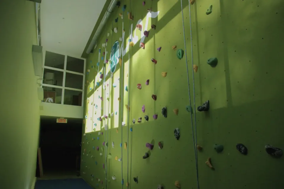 Indoor rock climbing wall with colorful holds and ropes
