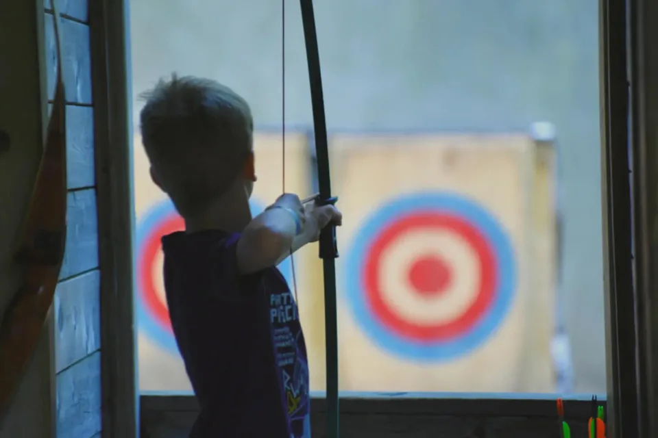 Enfant tirant à l’arc vers une cible.