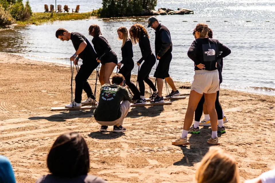 Group team-building exercise on sandy lakeside beach