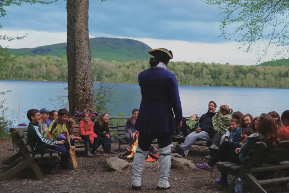 Enfants autour d’un feu de camp au bord du lac