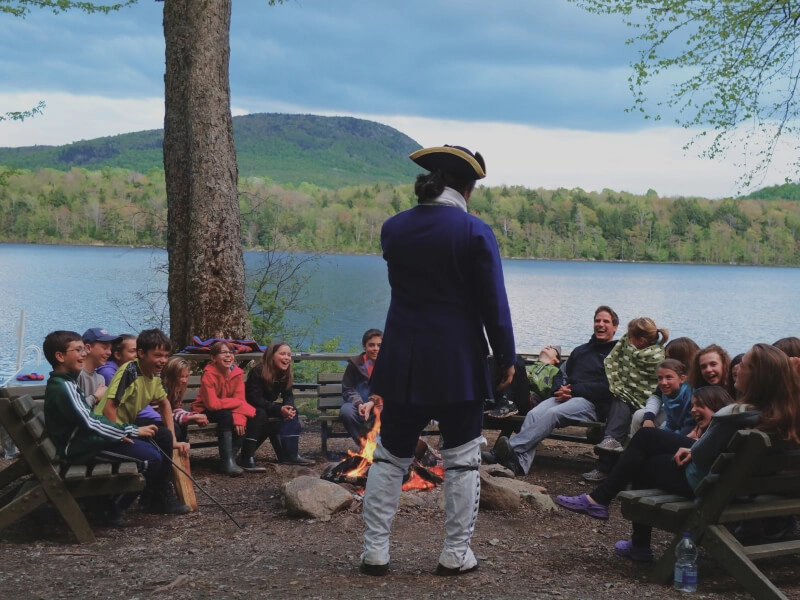 Groupe autour d’un feu de camp au bord du lac