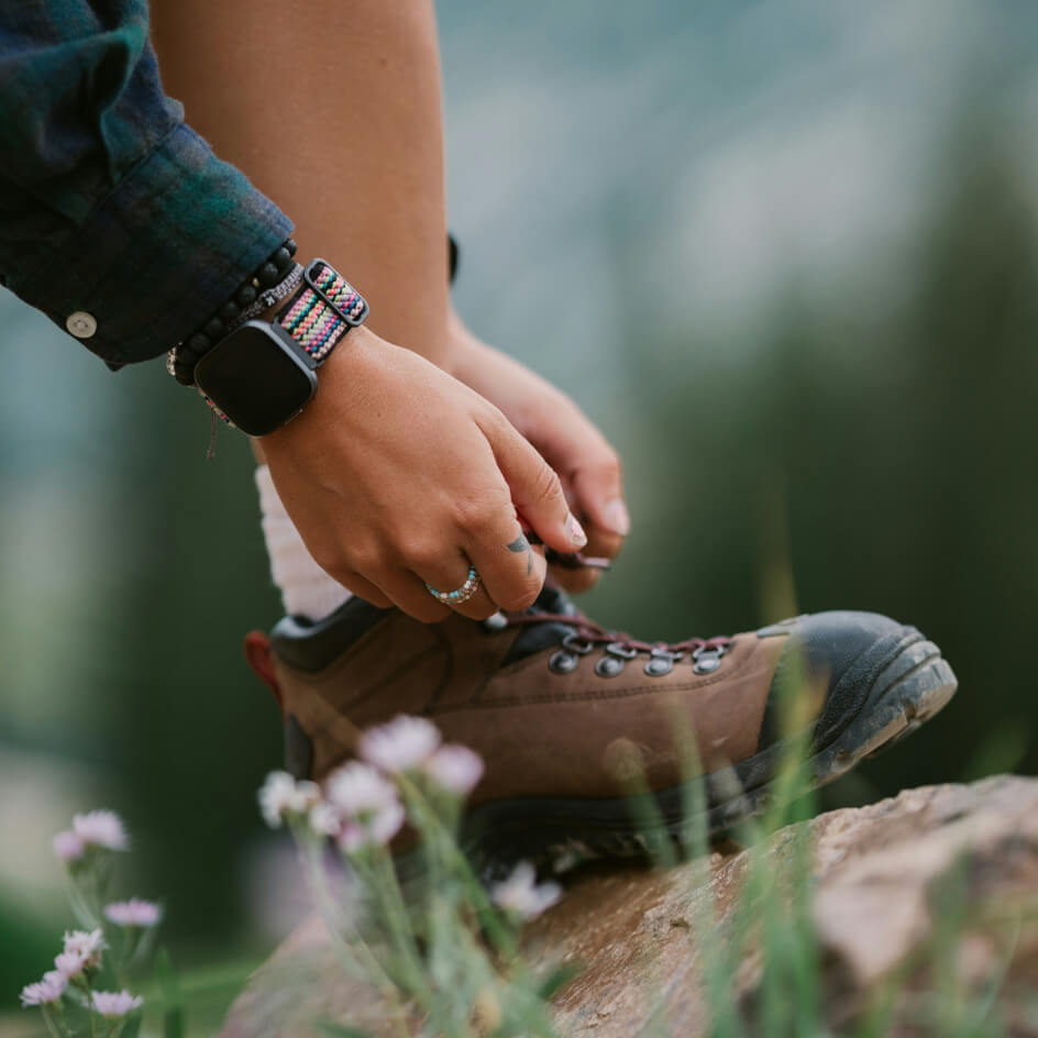 Personne laçant chaussure de randonnée en montagne