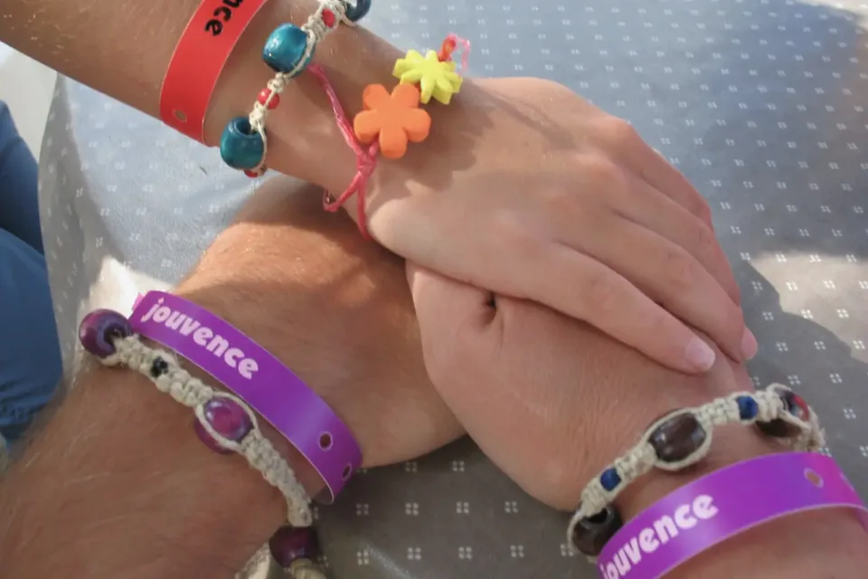 Trois mains enlacées avec bracelets colorés