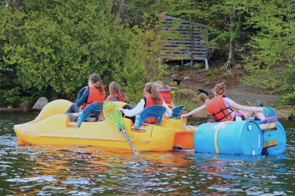 Children wearing life jackets on lake paddle boat