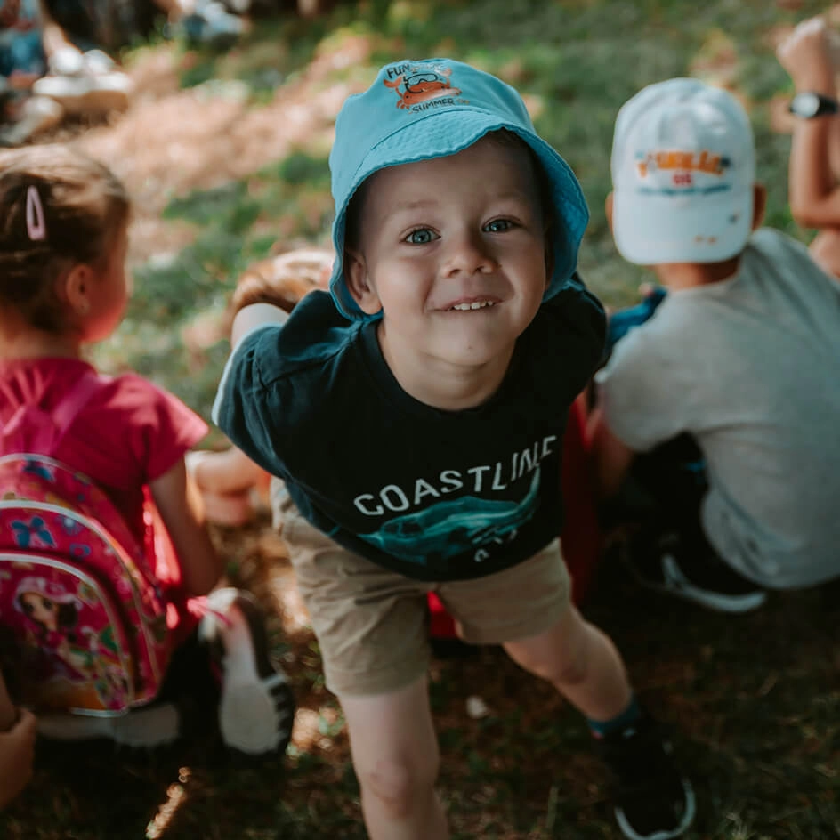 Smiling young boy in blue hat outdoors