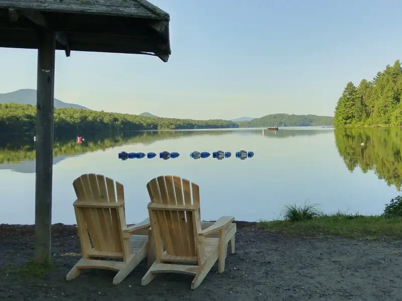 Deux chaises en bois face à un lac calme