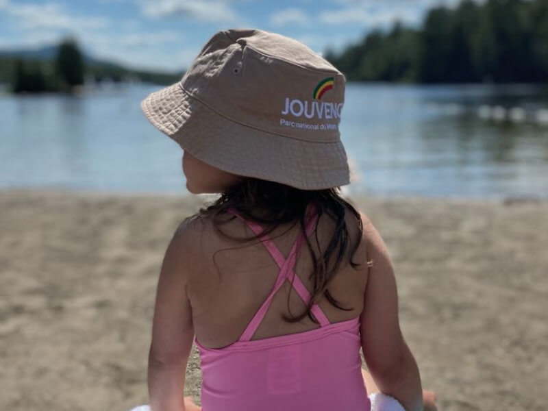 Enfant en maillot rose au bord d’un lac