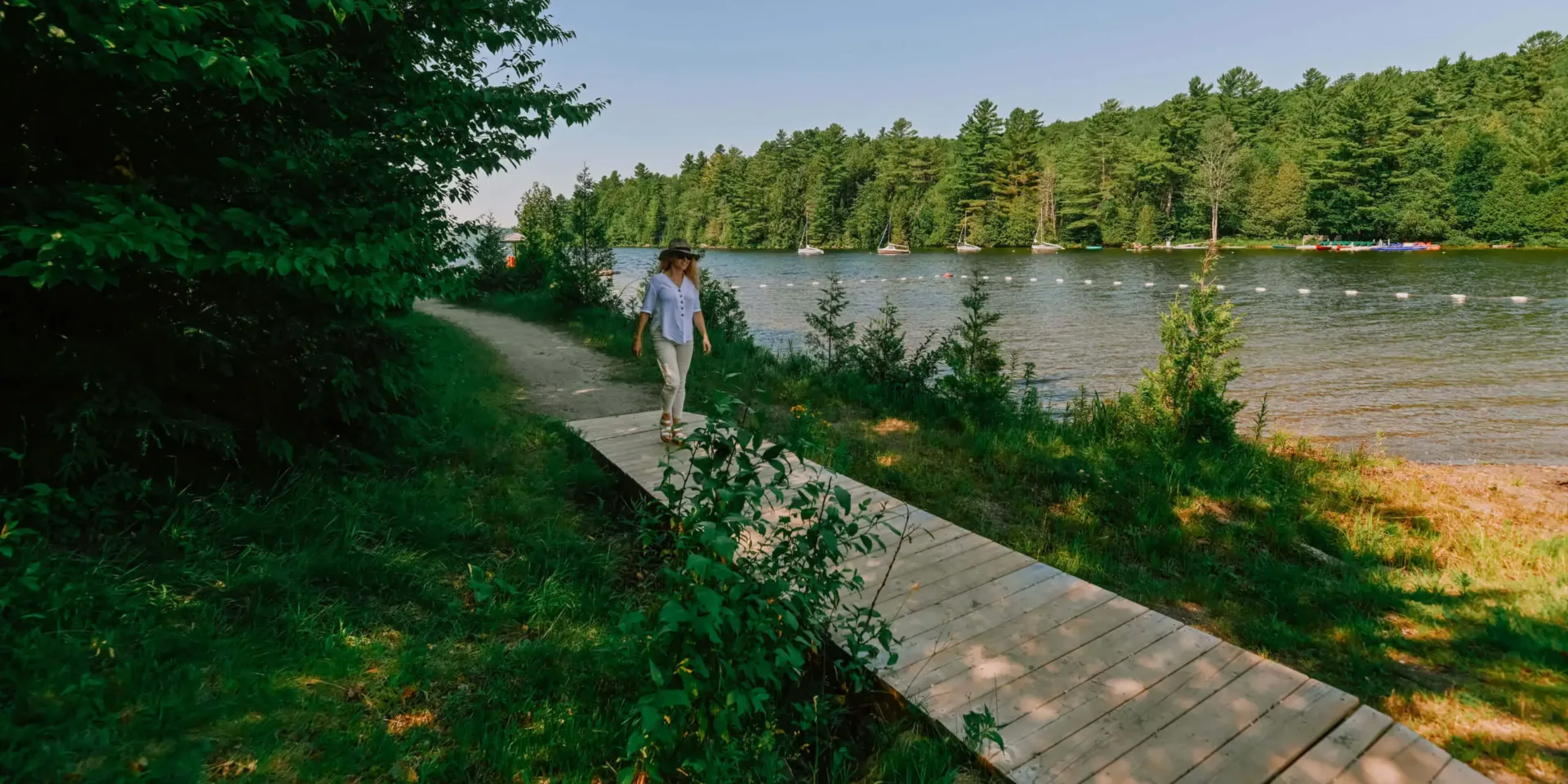 Femme marchant au bord d’un lac forestier