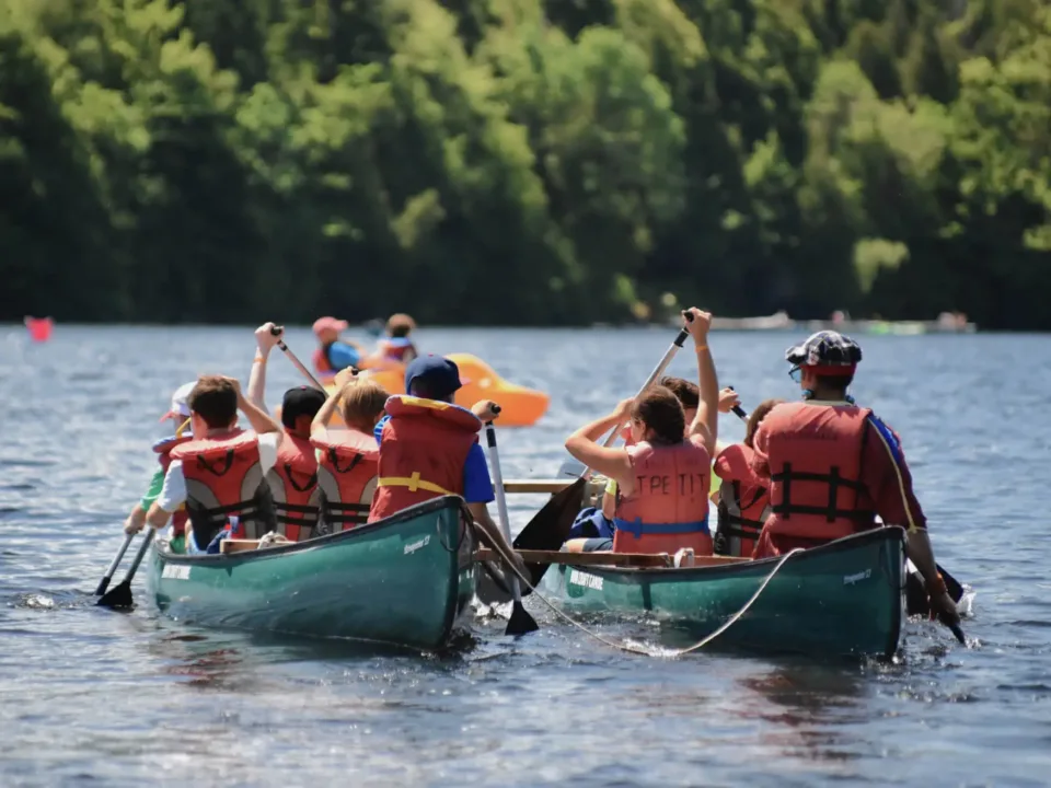 Children in a canoe on a lake surrounded by forest