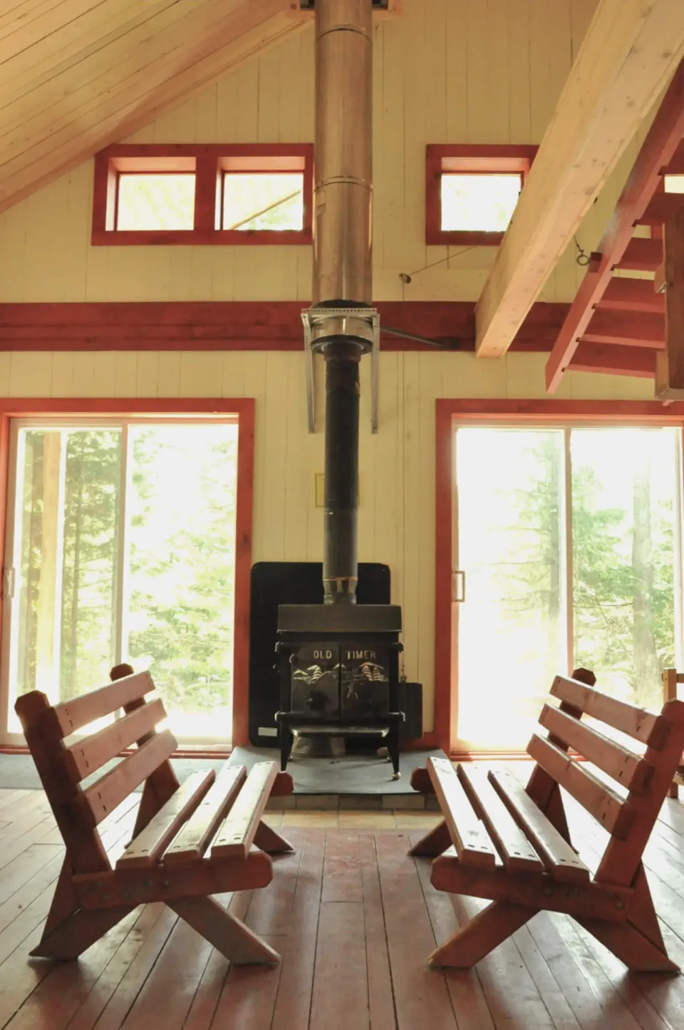 Rustic cabin interior with wood stove and benches