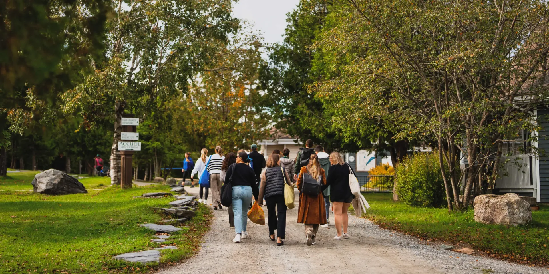 Groupe marchant vers accueil dans parc arboré