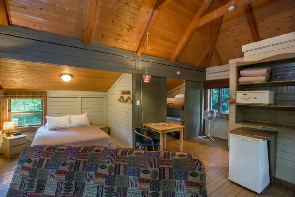 Rustic cabin bedroom with wooden ceiling and bunk beds