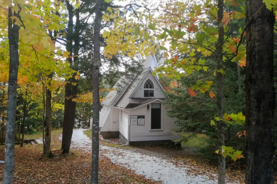 Petite chapelle blanche en forêt en automne