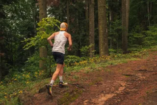 Runner jogging uphill on forest trail