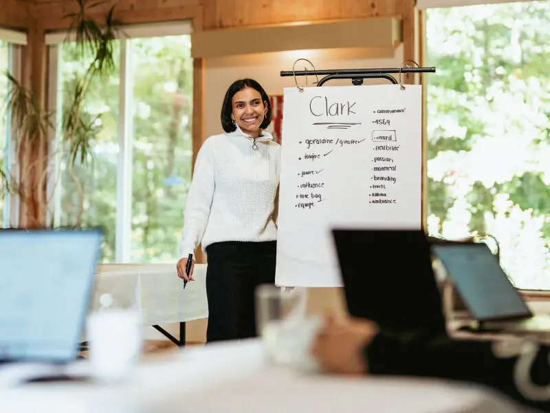 Femme présentant un tableau lors d'une réunion