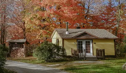 Small yellow cabin surrounded by autumn trees