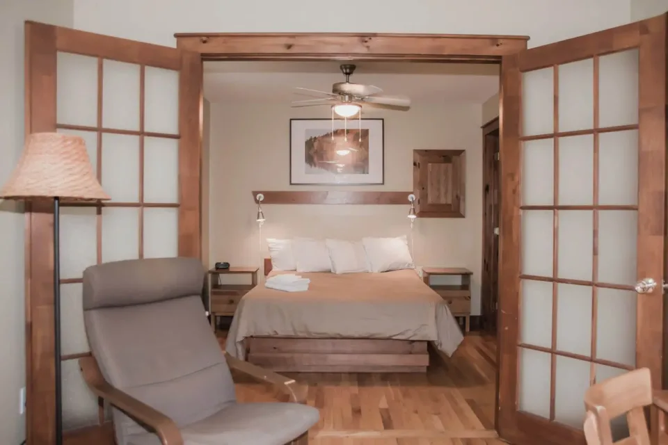 Cozy bedroom with wooden sliding doors and ceiling fan