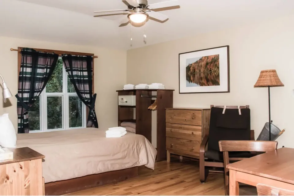 Cozy bedroom with wooden furniture and window.