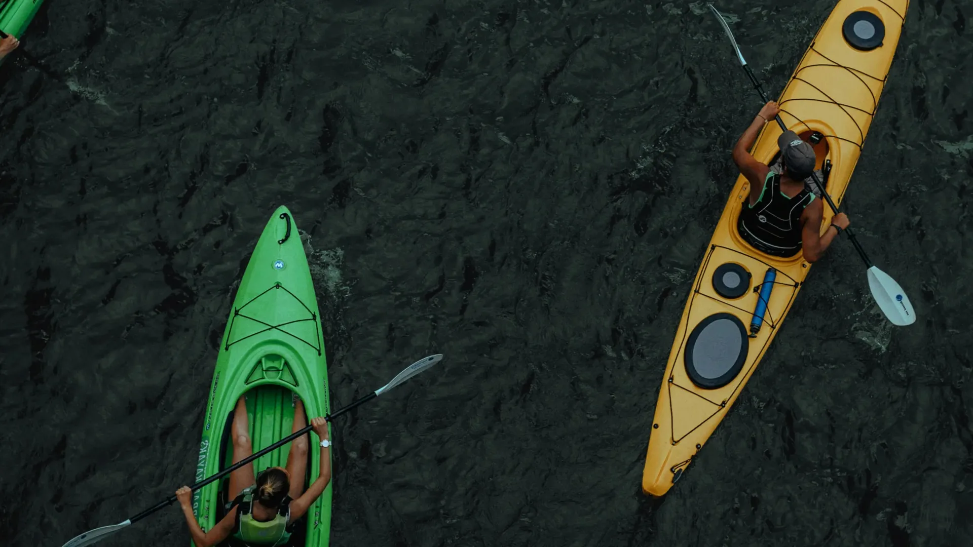 Aerial view of two kayakers on dark water