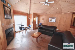 Cozy wood-paneled living room with fireplace and sofas