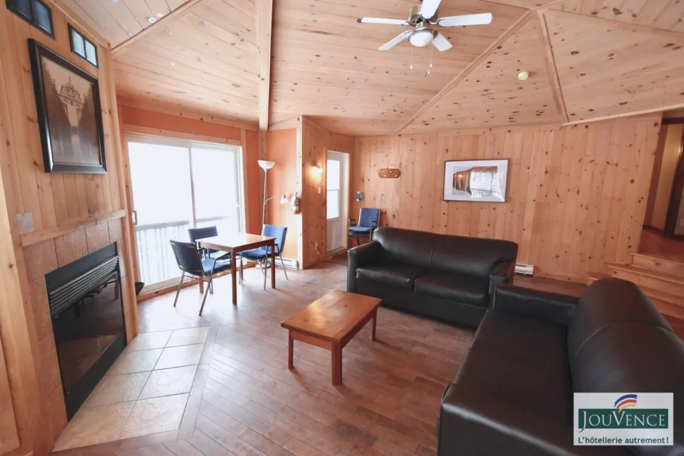 Cozy wood-paneled living room with fireplace and sofas