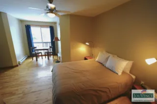 Cozy bedroom with bed, table, and balcony window