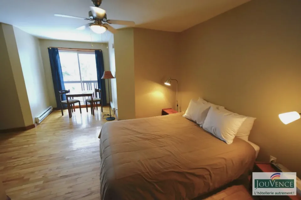 Cozy bedroom with bed, table, and balcony window
