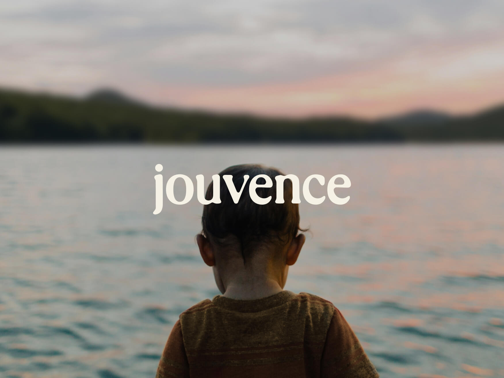 Enfant regardant lac au coucher du soleil