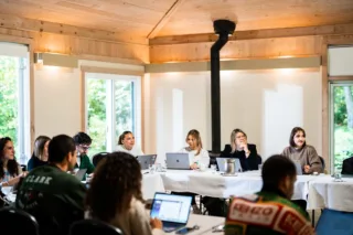 Réunion professionnelle avec ordinateurs dans salle en bois