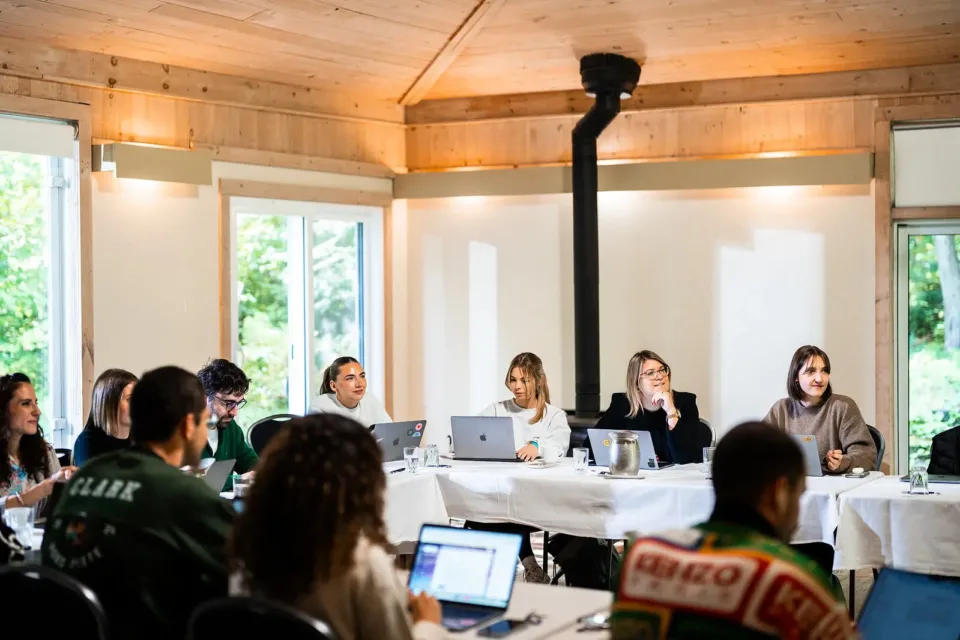 Réunion professionnelle avec ordinateurs dans salle en bois