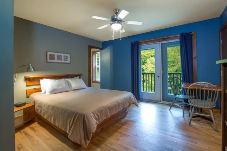 Modern bedroom with wooden bed and balcony doors