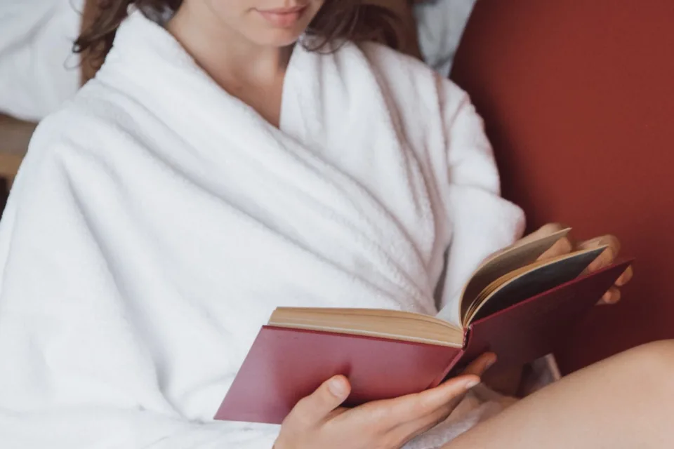 Personne tenant une tasse en lisant un livre