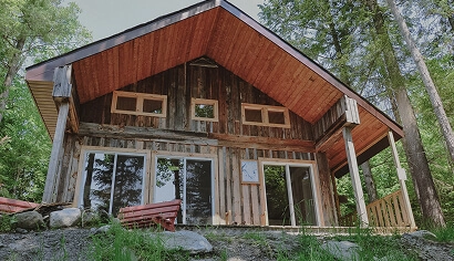 Rustic wooden cabin with large windows in forest