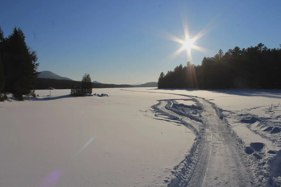 Lac gelé enneigé sous soleil d’hiver