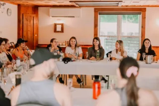 Women smiling during indoor workshop roundtable discussion