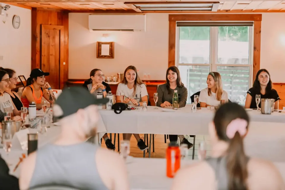 Women smiling during indoor workshop roundtable discussion