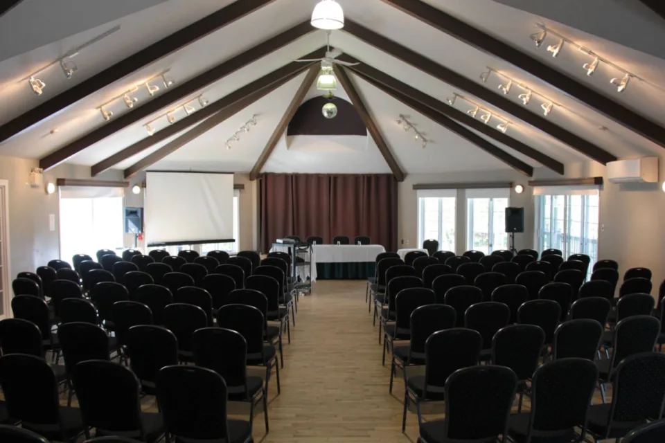 Salle de conférence avec chaises et écran de projection