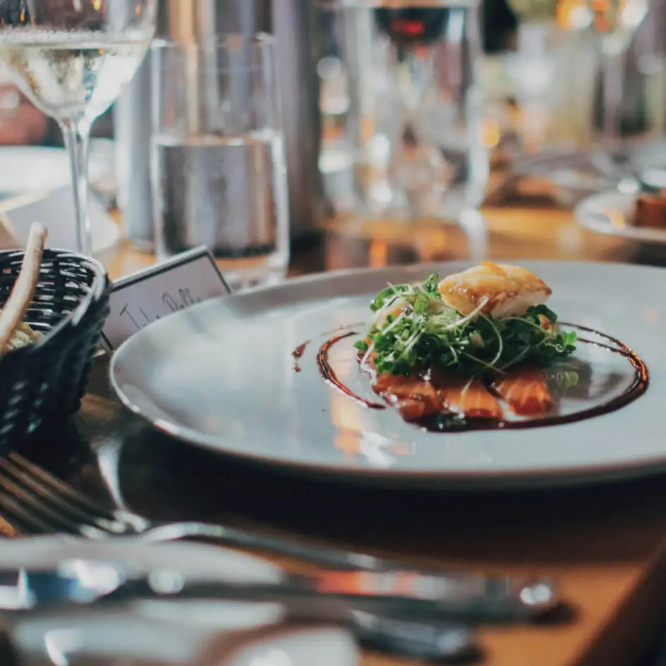 Gourmet salmon dish with greens on restaurant table
