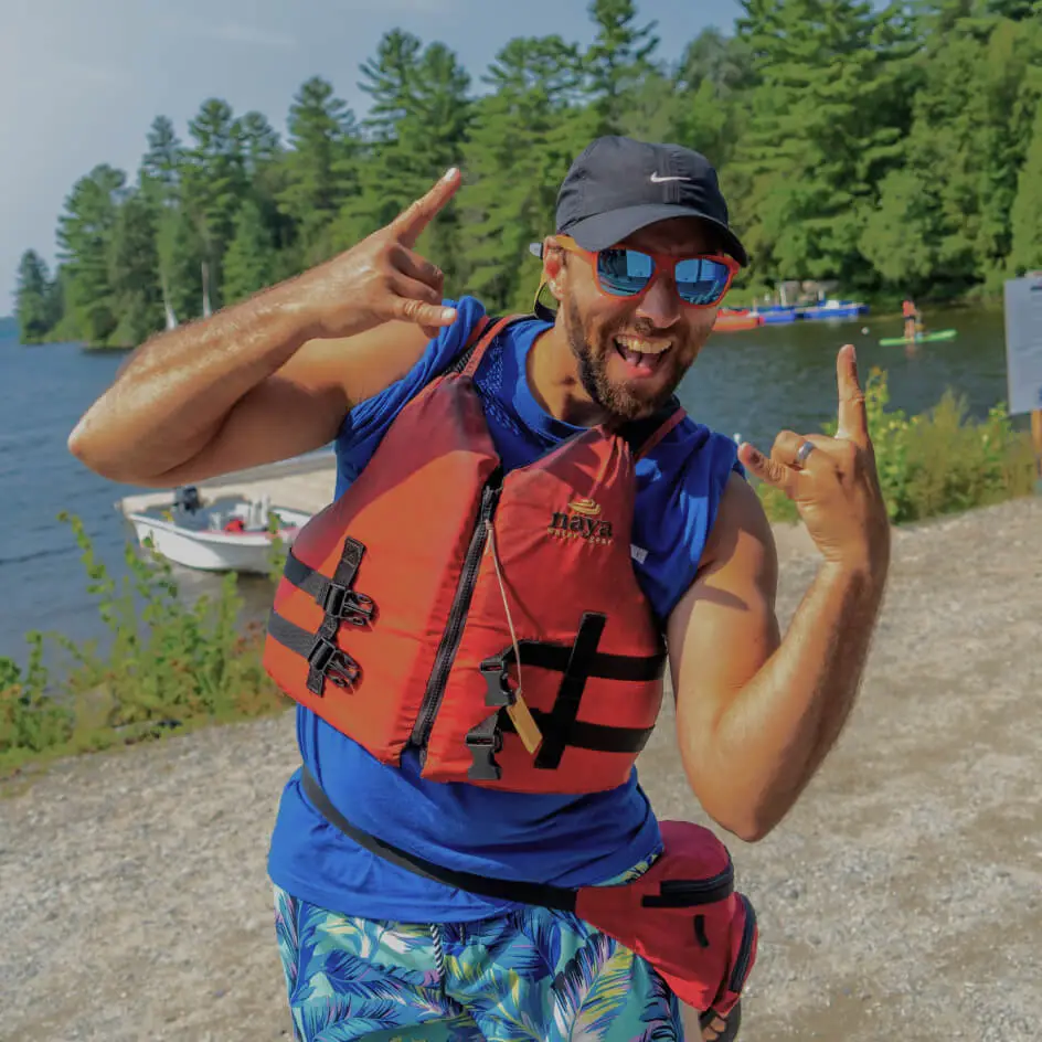 Homme souriant en gilet de sauvetage au lac