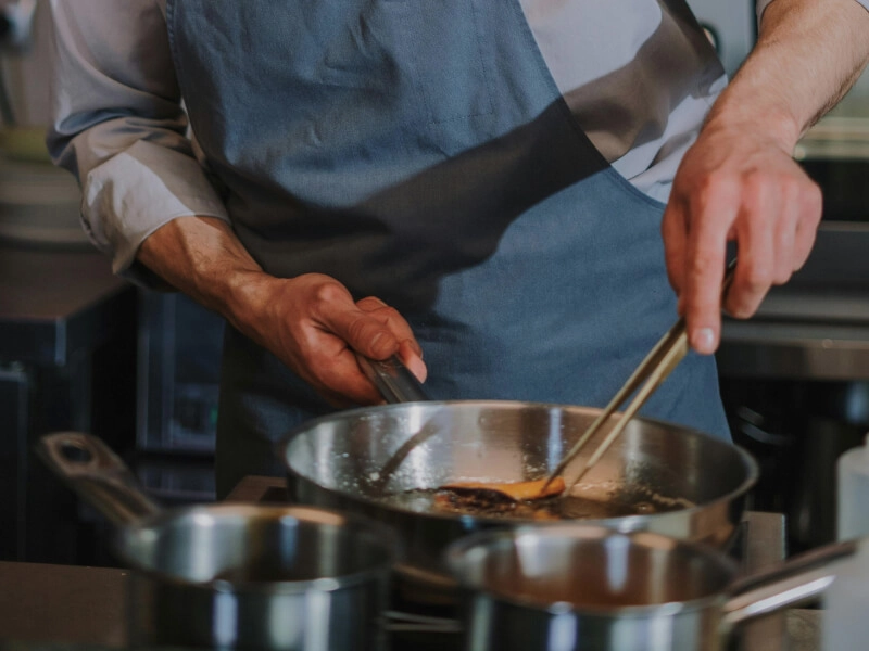 Chef cuisinant à la poêle en cuisine professionnelle
